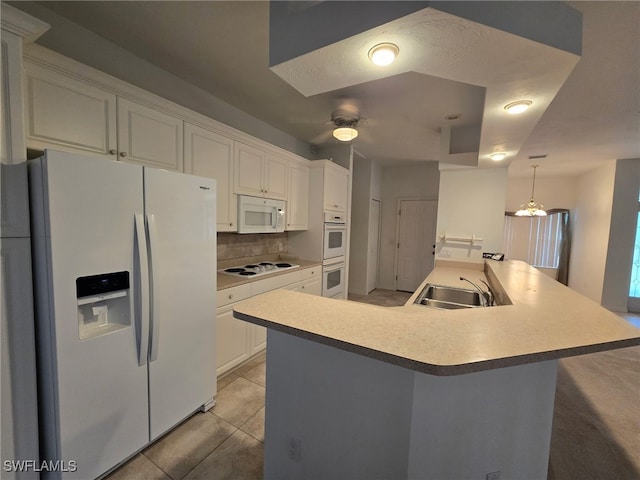 kitchen with sink, white cabinetry, hanging light fixtures, a center island with sink, and white appliances