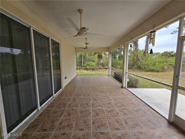 unfurnished sunroom featuring ceiling fan