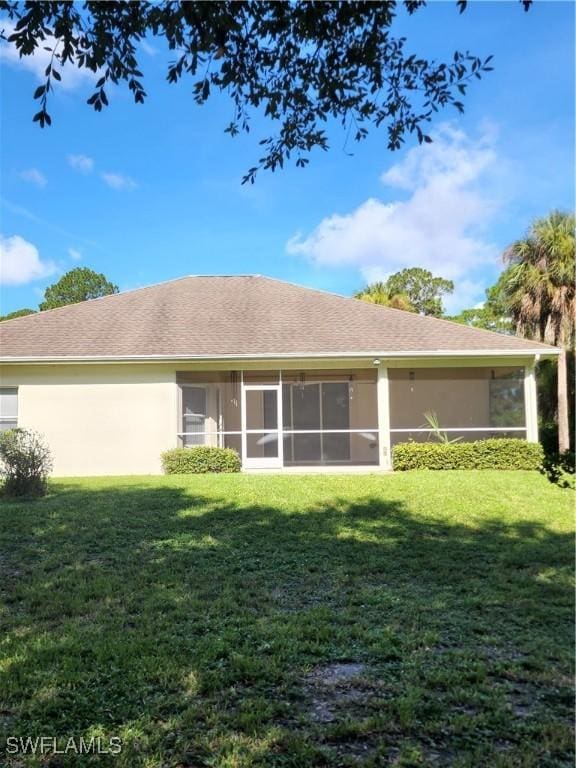 rear view of property with a lawn