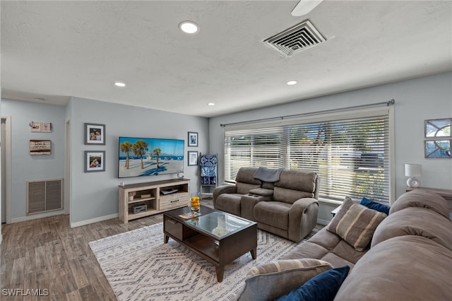 living room featuring a textured ceiling and light wood-type flooring