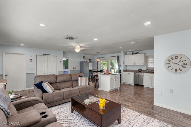 living room with sink, ceiling fan, and light wood-type flooring