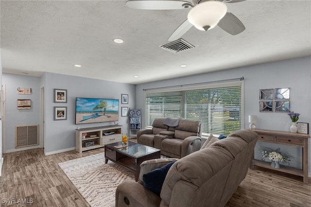 living room with ceiling fan, hardwood / wood-style floors, and a textured ceiling