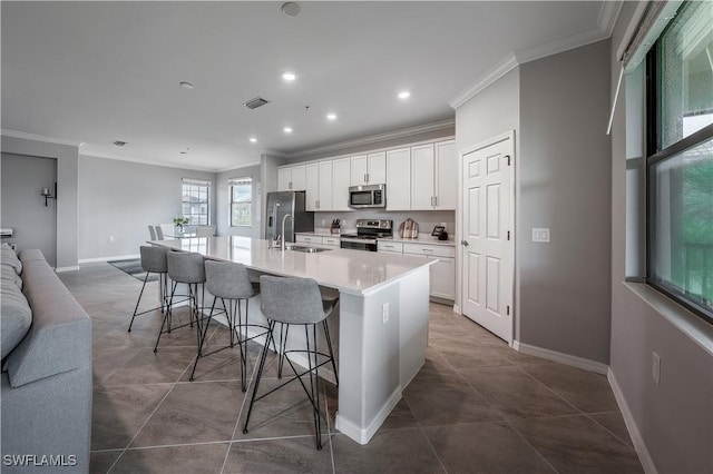 kitchen featuring a breakfast bar, visible vents, white cabinets, appliances with stainless steel finishes, and a large island