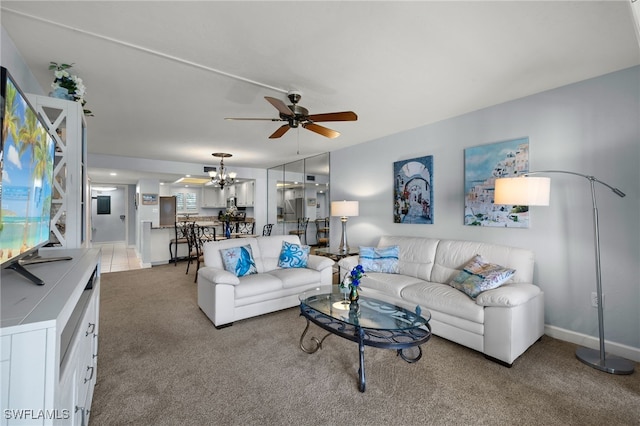 living room with ceiling fan with notable chandelier and light carpet