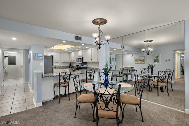 carpeted dining room with a chandelier