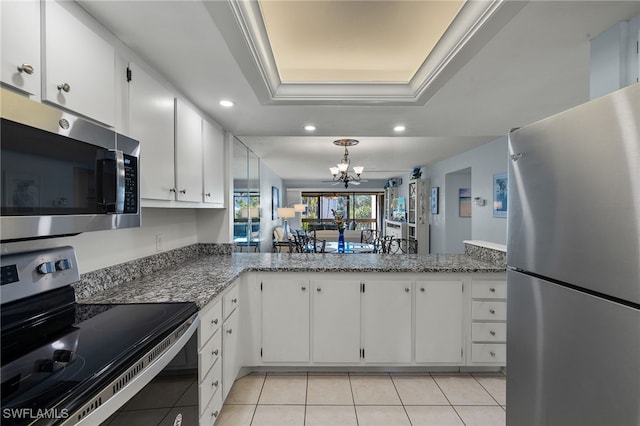 kitchen featuring stainless steel appliances, white cabinetry, a raised ceiling, and kitchen peninsula