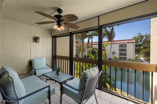 sunroom / solarium with a water view and ceiling fan