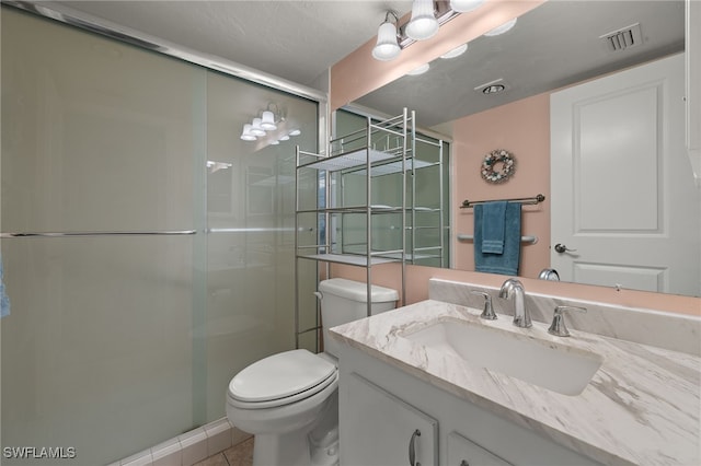 bathroom with vanity, a shower with shower door, tile patterned floors, and toilet