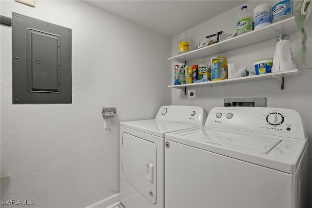 laundry room featuring electric panel and washer and clothes dryer