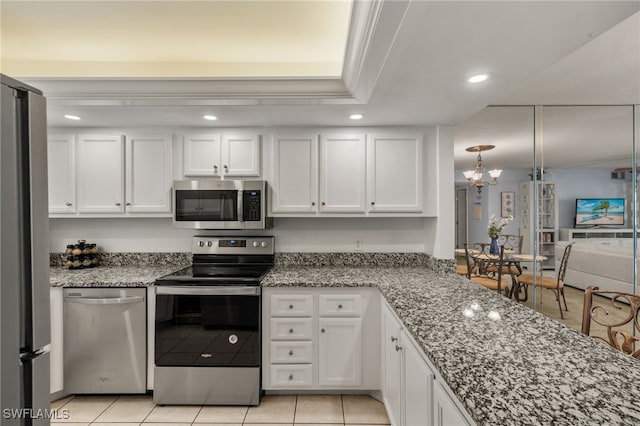 kitchen with light tile patterned flooring, white cabinetry, light stone counters, decorative light fixtures, and stainless steel appliances