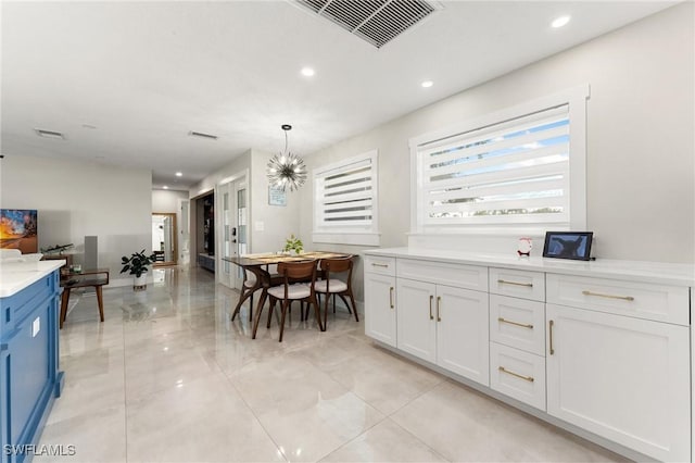 kitchen featuring white cabinetry, hanging light fixtures, and a notable chandelier