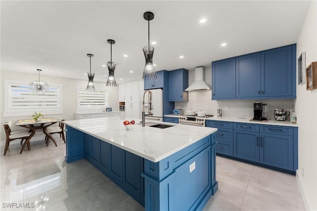 kitchen with white appliances, a spacious island, light stone countertops, decorative light fixtures, and wall chimney exhaust hood