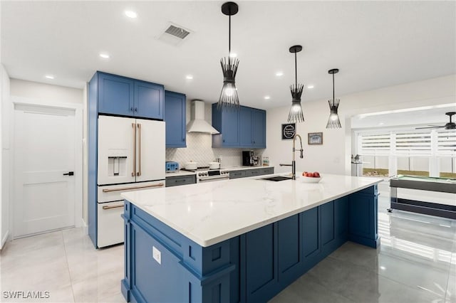 kitchen featuring high end white refrigerator, wall chimney exhaust hood, pendant lighting, a large island, and light stone countertops