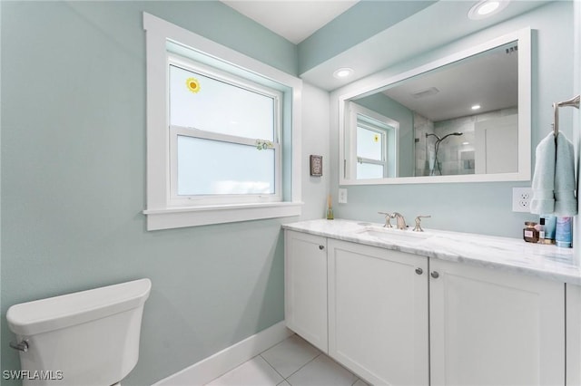 bathroom with vanity, a tile shower, tile patterned floors, and toilet