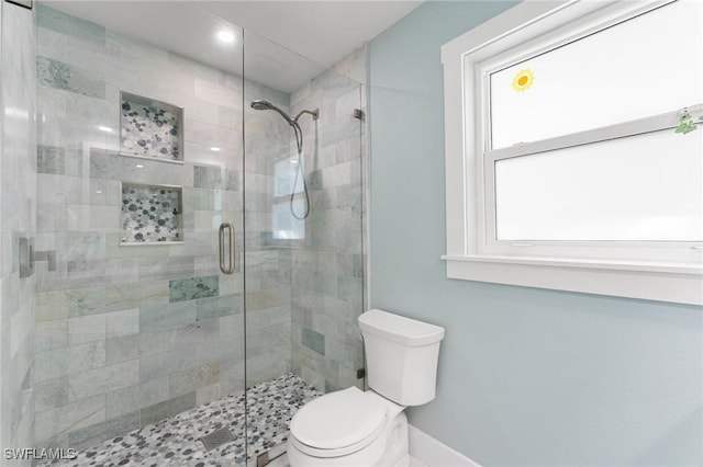 bathroom with toilet and a shower with shower door