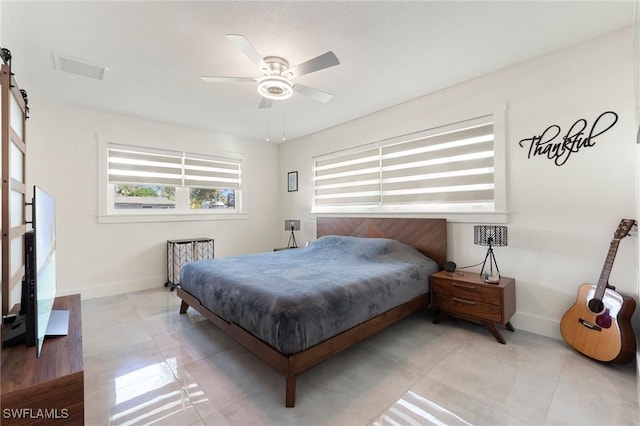 bedroom featuring light tile patterned floors, a barn door, and ceiling fan