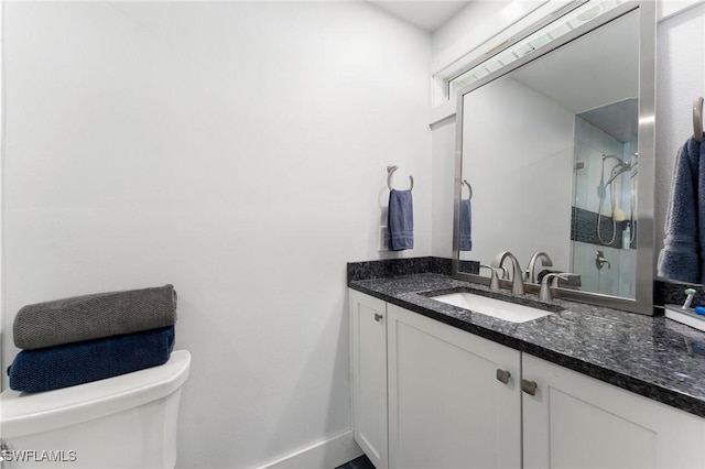 bathroom with vanity, toilet, and a shower with door