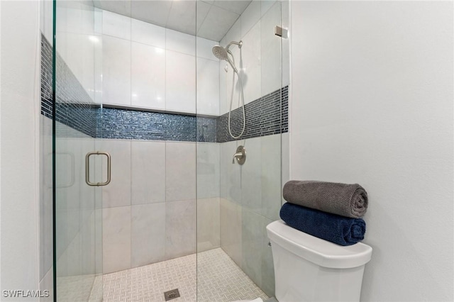 bathroom with toilet and a shower with shower door