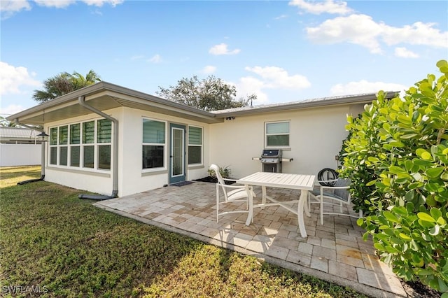 back of property with a yard and a patio area