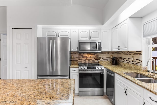 kitchen with white cabinetry, stainless steel appliances, sink, and light stone counters