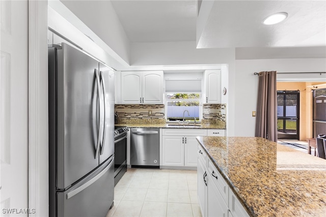 kitchen featuring light stone counters, sink, white cabinets, and appliances with stainless steel finishes