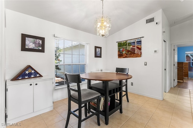 tiled dining area with an inviting chandelier and lofted ceiling