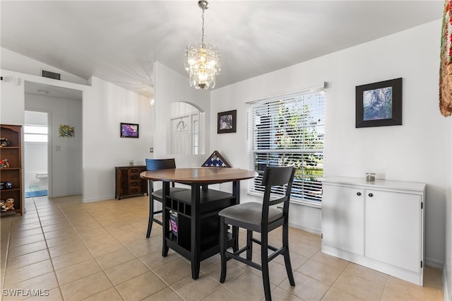 dining room featuring light tile patterned floors, a notable chandelier, and vaulted ceiling