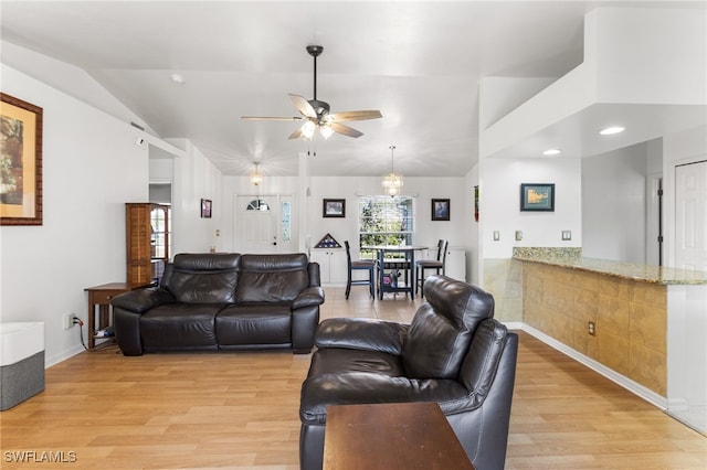 living room with ceiling fan, lofted ceiling, and light hardwood / wood-style floors