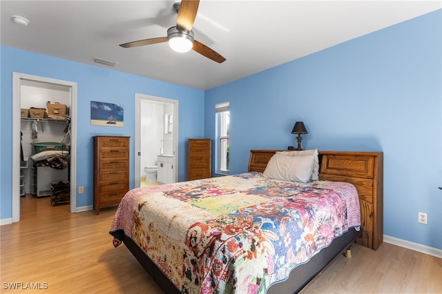 bedroom with ceiling fan, a spacious closet, light wood-type flooring, and a closet