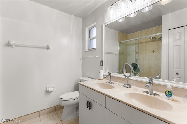 bathroom featuring tiled shower, tile patterned floors, toilet, and vanity