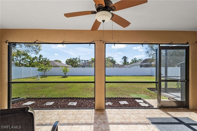 unfurnished sunroom featuring ceiling fan