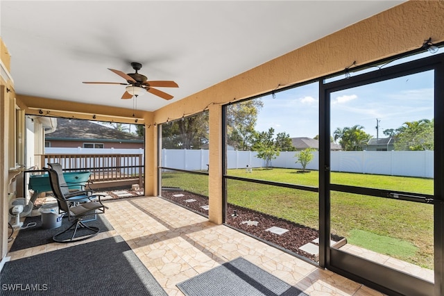 unfurnished sunroom featuring plenty of natural light and ceiling fan