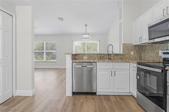 kitchen featuring stainless steel appliances, light stone countertops, sink, and white cabinets