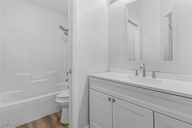 full bathroom featuring hardwood / wood-style flooring, shower / washtub combination, vanity, and toilet