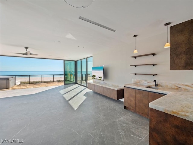 interior space featuring ceiling fan, floor to ceiling windows, and sink