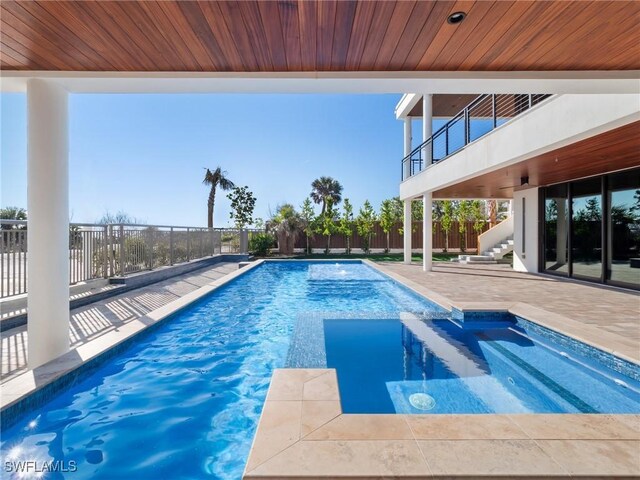 view of swimming pool featuring a patio and an in ground hot tub