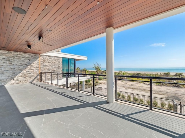 view of patio featuring ceiling fan, a balcony, and a water view