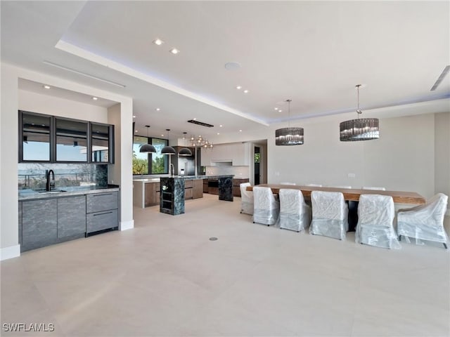 living room featuring sink and a tray ceiling