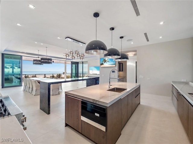 kitchen with a large island, sink, and decorative light fixtures