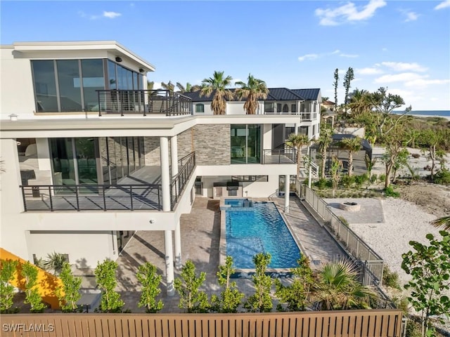 back of property featuring a balcony, a fenced in pool, and a patio area