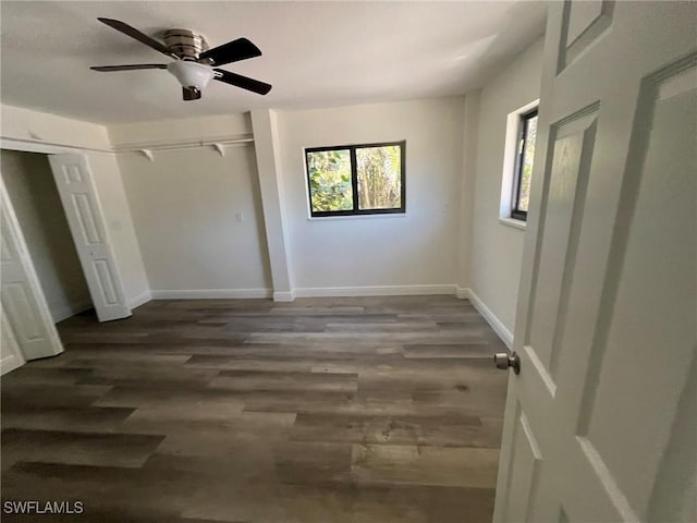 unfurnished bedroom with multiple windows, ceiling fan, dark hardwood / wood-style flooring, and a closet