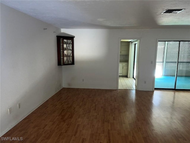 spare room featuring a textured ceiling and light wood-type flooring