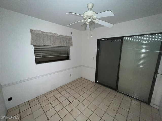 empty room featuring light tile patterned floors and ceiling fan