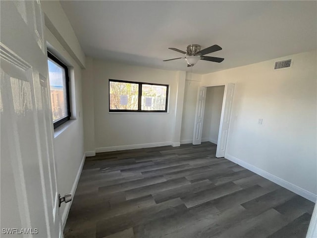 empty room featuring dark wood-type flooring and ceiling fan