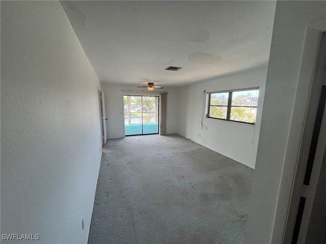 21551 Madera Rd, Fort Myers Beach, FL 33931 - empty room with plenty of natural light, light colored carpet, and ceiling fan