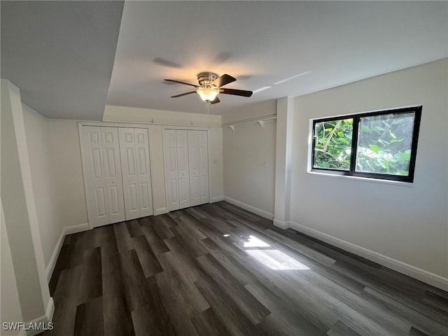 21551 Madera Rd, Fort Myers Beach, FL 33931 - unfurnished bedroom featuring dark wood finished floors, multiple closets, and ceiling fan