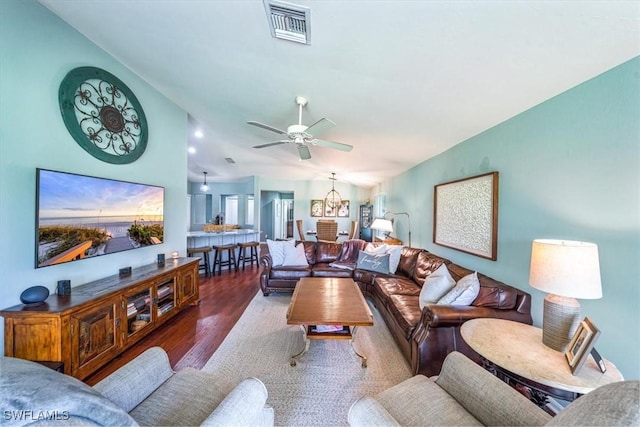 living room with lofted ceiling, hardwood / wood-style floors, and ceiling fan