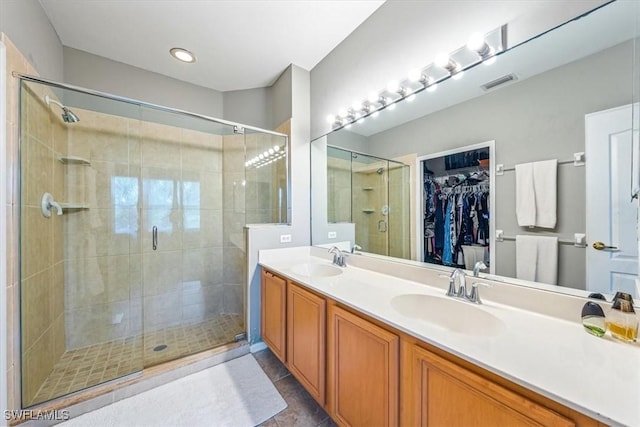 bathroom featuring a shower with door, vanity, and tile patterned flooring