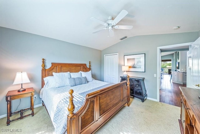 bedroom with lofted ceiling, carpet floors, a closet, and ceiling fan