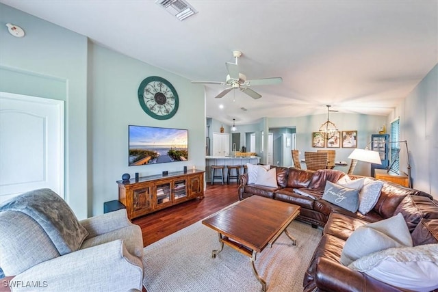 living room featuring lofted ceiling, dark wood-type flooring, and ceiling fan